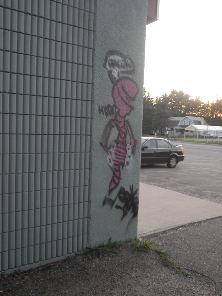 Pink worm graffiti character on building corner
